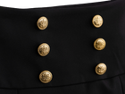 Gold button detail on the black mini skirt