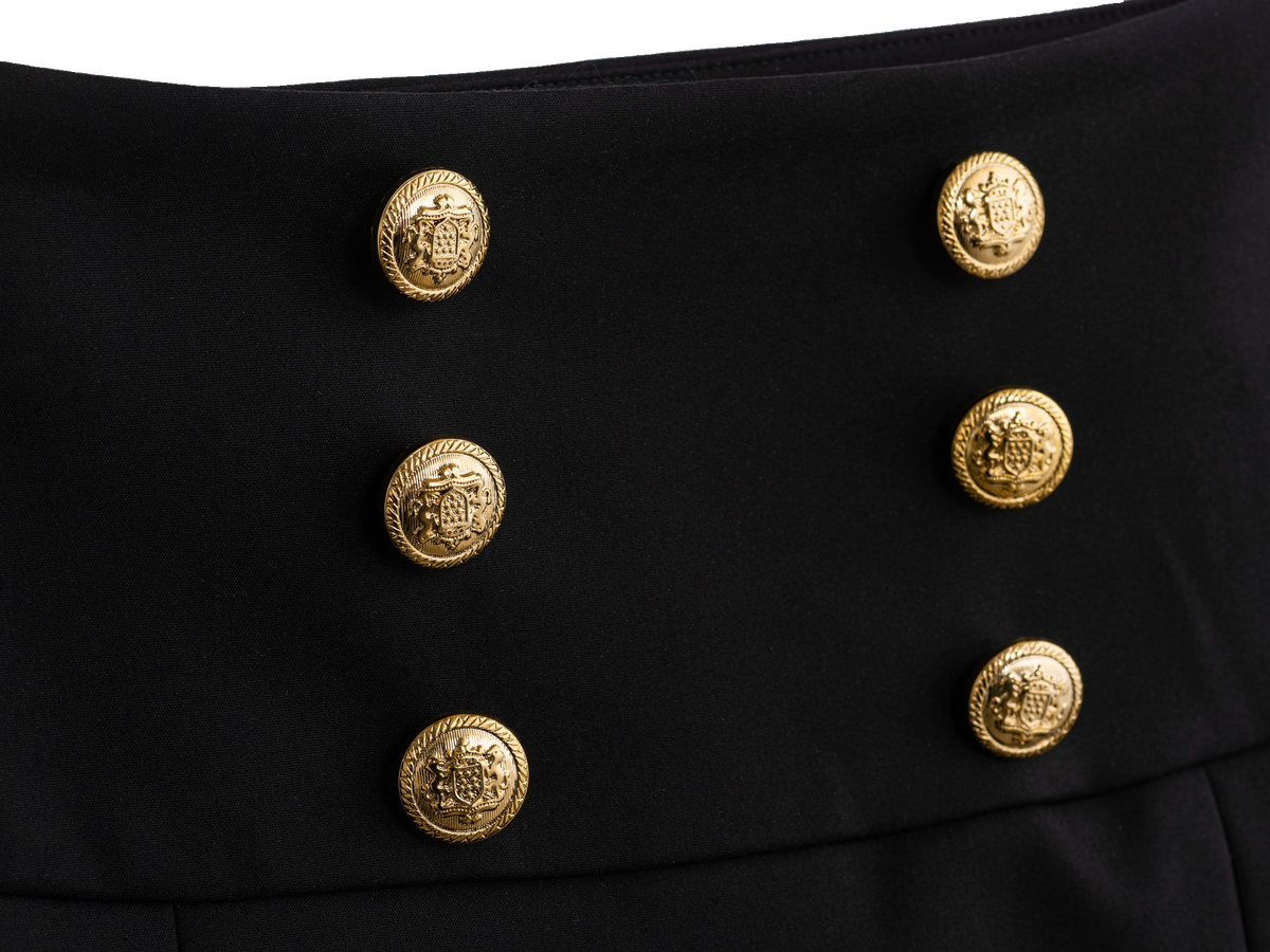 Gold button detail on the black mini skirt