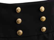 Gold button detail on the black mini skirt