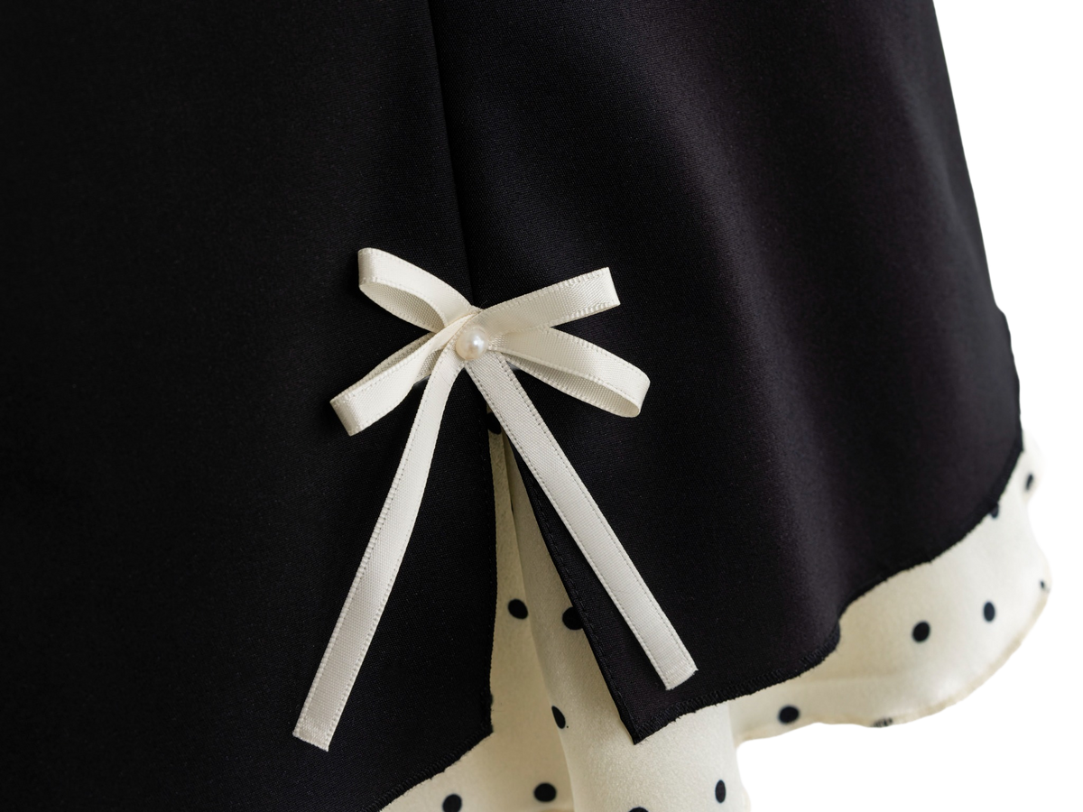 Satin ribbon bow detail on the black polka dot mini skirt