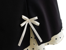 Satin ribbon bow detail on the black polka dot mini skirt