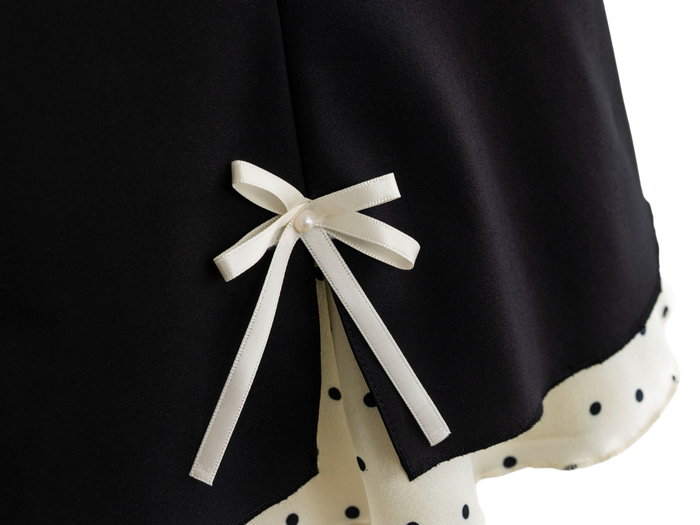 Satin ribbon bow detail on the black polka dot mini skirt