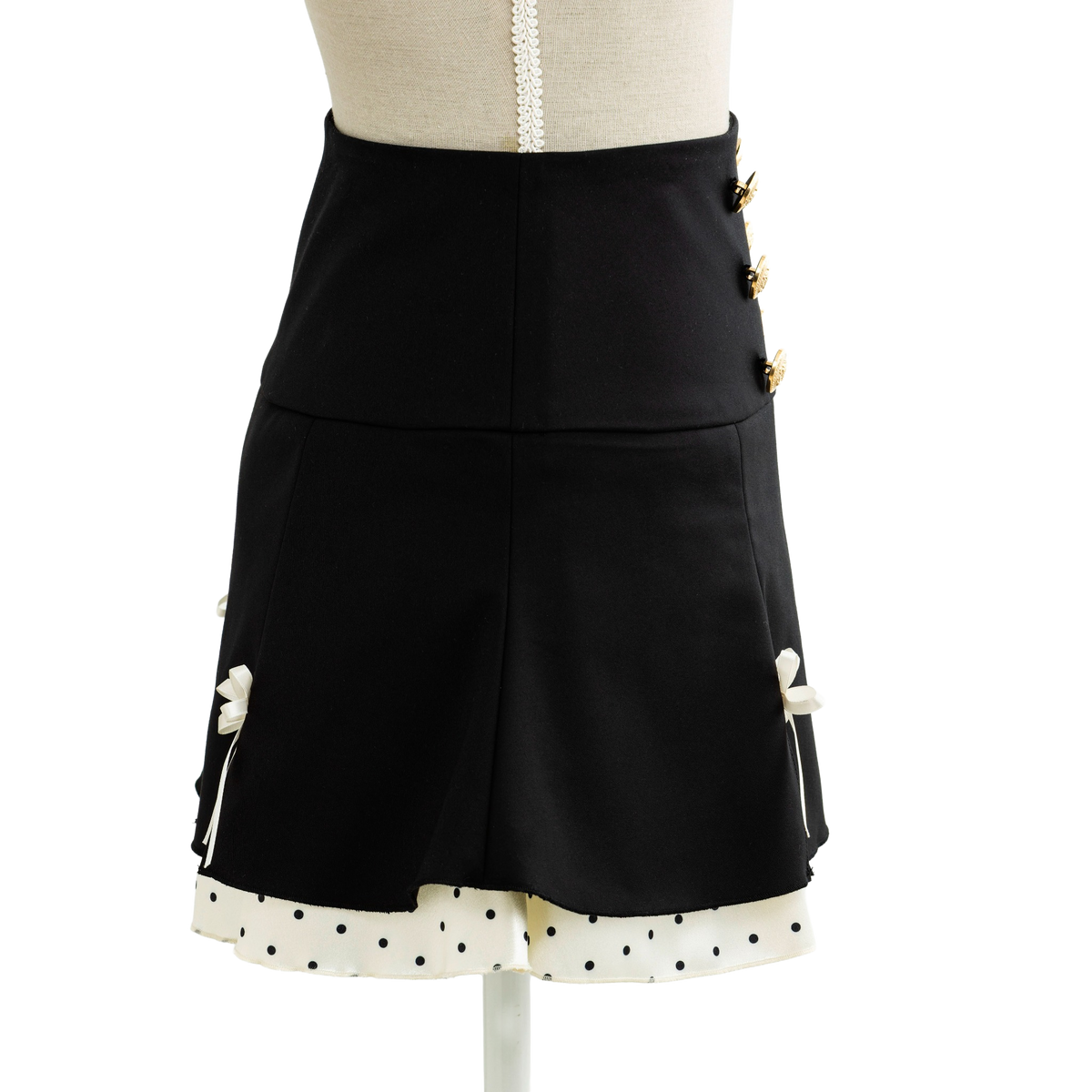 Black mini skirt with gold buttons and a dotted trim, side view