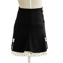 Black mini skirt with gold buttons and a dotted trim, side view