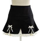 Black coquette mini skirt with white bows and a scalloped dotted hem