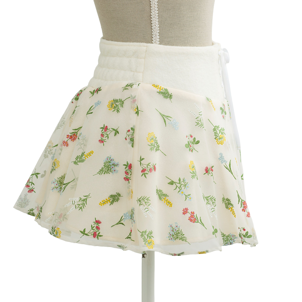 Floral print mini skirt in cream, flared shape on a mannequin