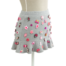 Charm mini skirt in grey with pink charms, styled on a mannequin