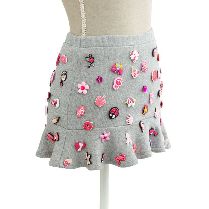 Charm mini skirt in grey with pink charms, styled on a mannequin