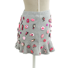 Side view of the grey charm mini skirt with a flared ruffle hem