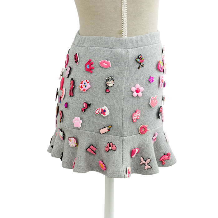 Side view of the grey charm mini skirt with a flared ruffle hem
