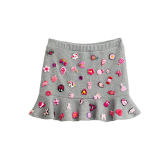 Grey charm mini skirt with removable pink charms and a ruffle hem, front view