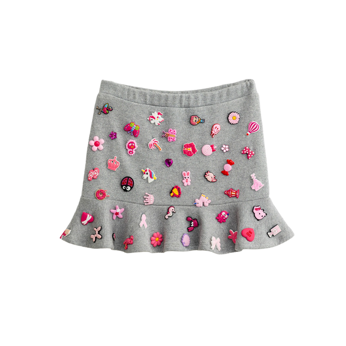 Grey charm mini skirt with removable pink charms and a ruffle hem, front view