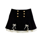 Black polka dot mini skirt with satin ribbon bows, front view