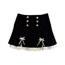 Black polka dot mini skirt with satin ribbon bows, front view